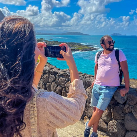 OPT Guest capturing a photo of her partner at a scenic Oahu lookout, showcasing breathtaking island views.